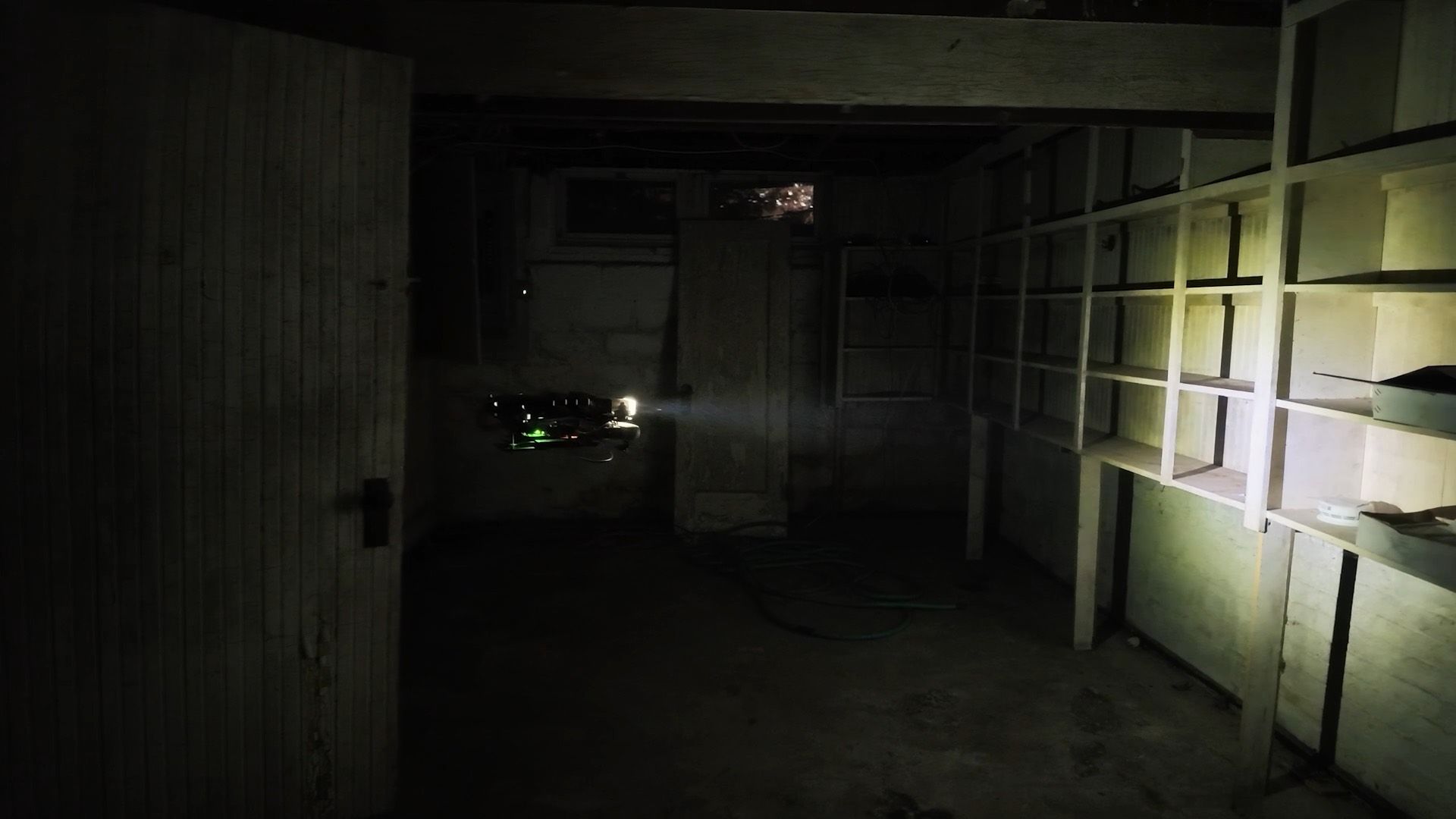 Our drone flying through a dark basement, lit only by its own light
